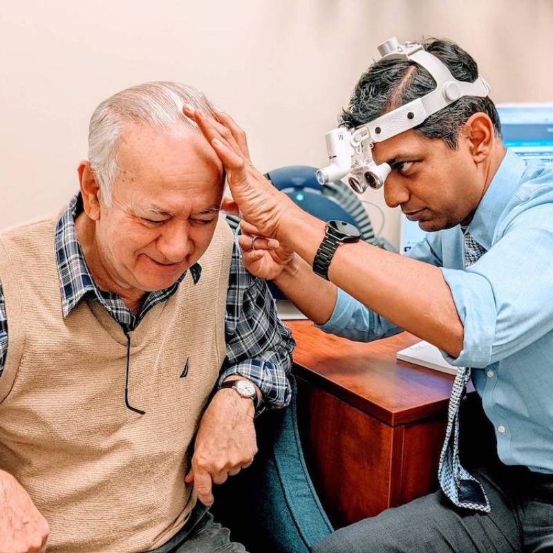 audiologist checking patient's ear